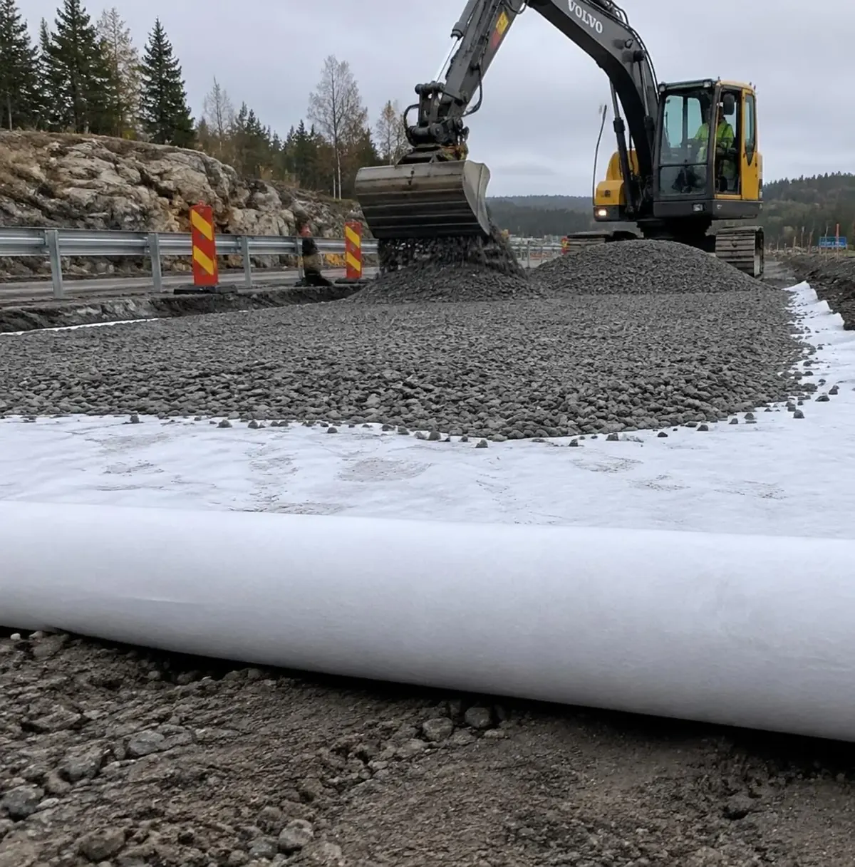 Illustration: geotextil utlagd under bärlager på en väg